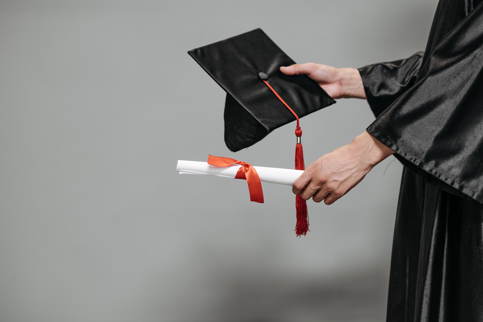 Photo of Person Holding Graduation Cap and Diploma